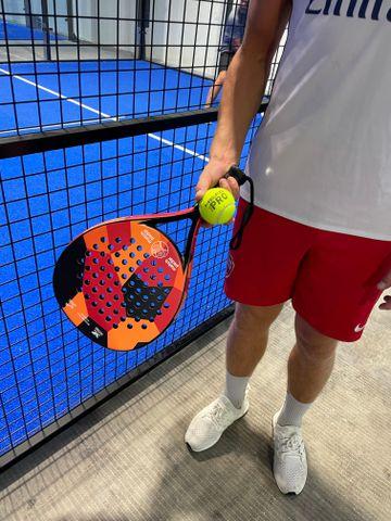 Ung mand med et padelbat og en bold