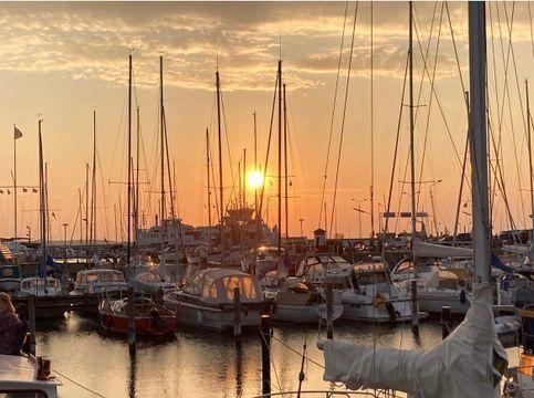 Solnedgang over bådene i Hundested Havn