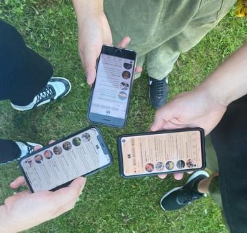 Tre personer står med deres telefoner, som er logget ind på boblberg app'en