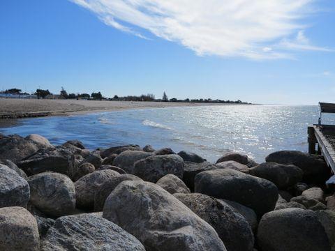 Et naturskønt billede af stranden med stroe sten i forgrunden
