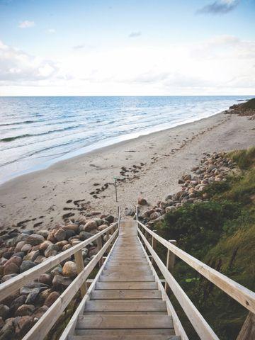 En lang trappe ned til stranden med udsigt over vandet