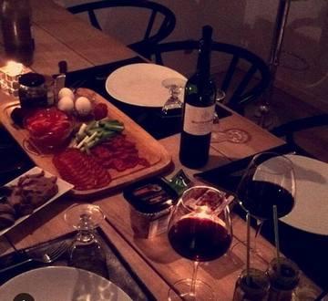 Et hyggeligt dækket bord med vin og tapas står klar til gæsterne, når madklubben kommer på besøg
